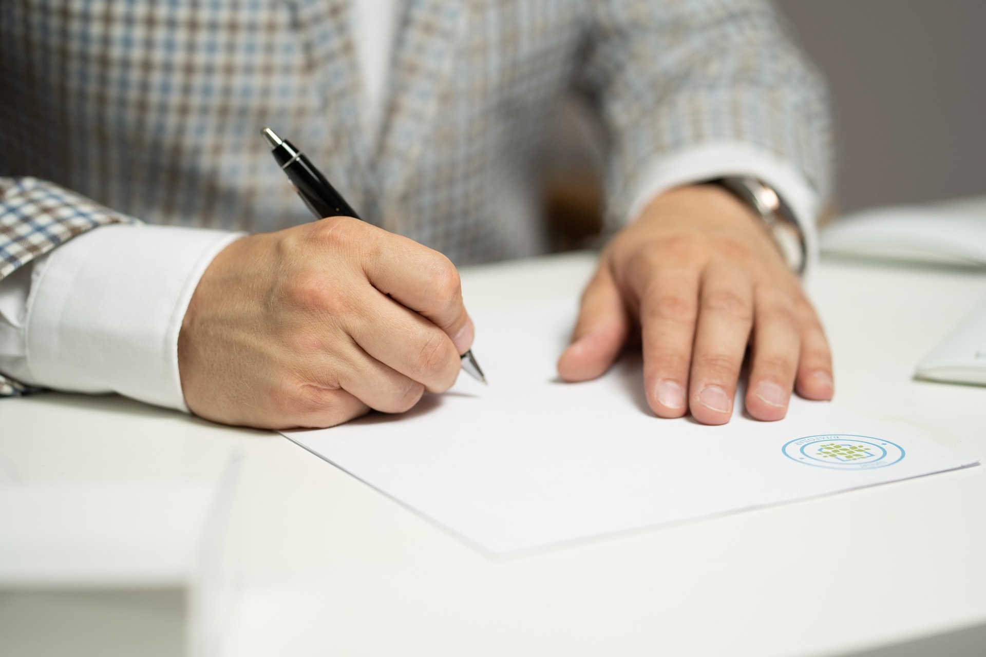 A man is writing something on the paper.