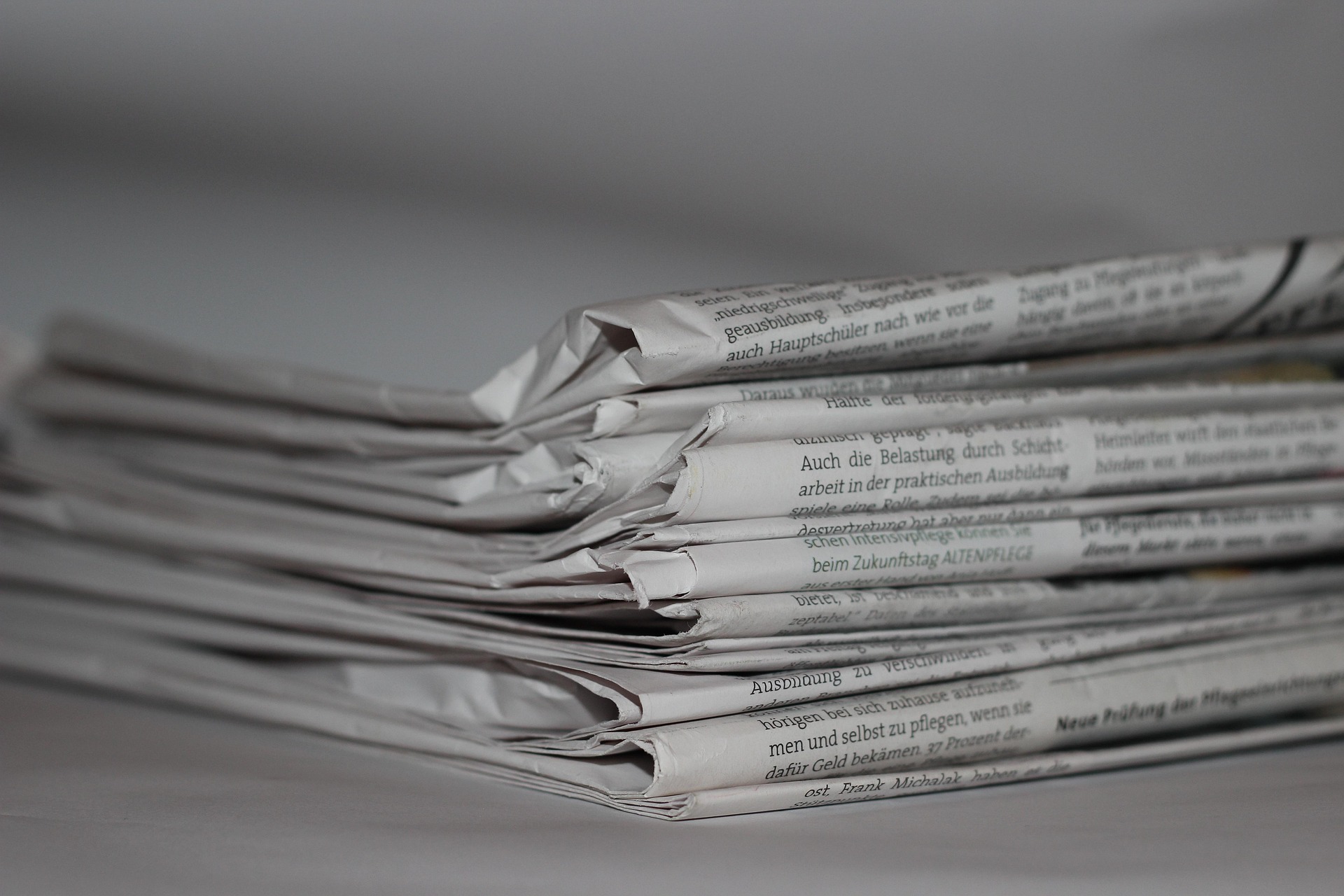 The newspapers lying on the table.