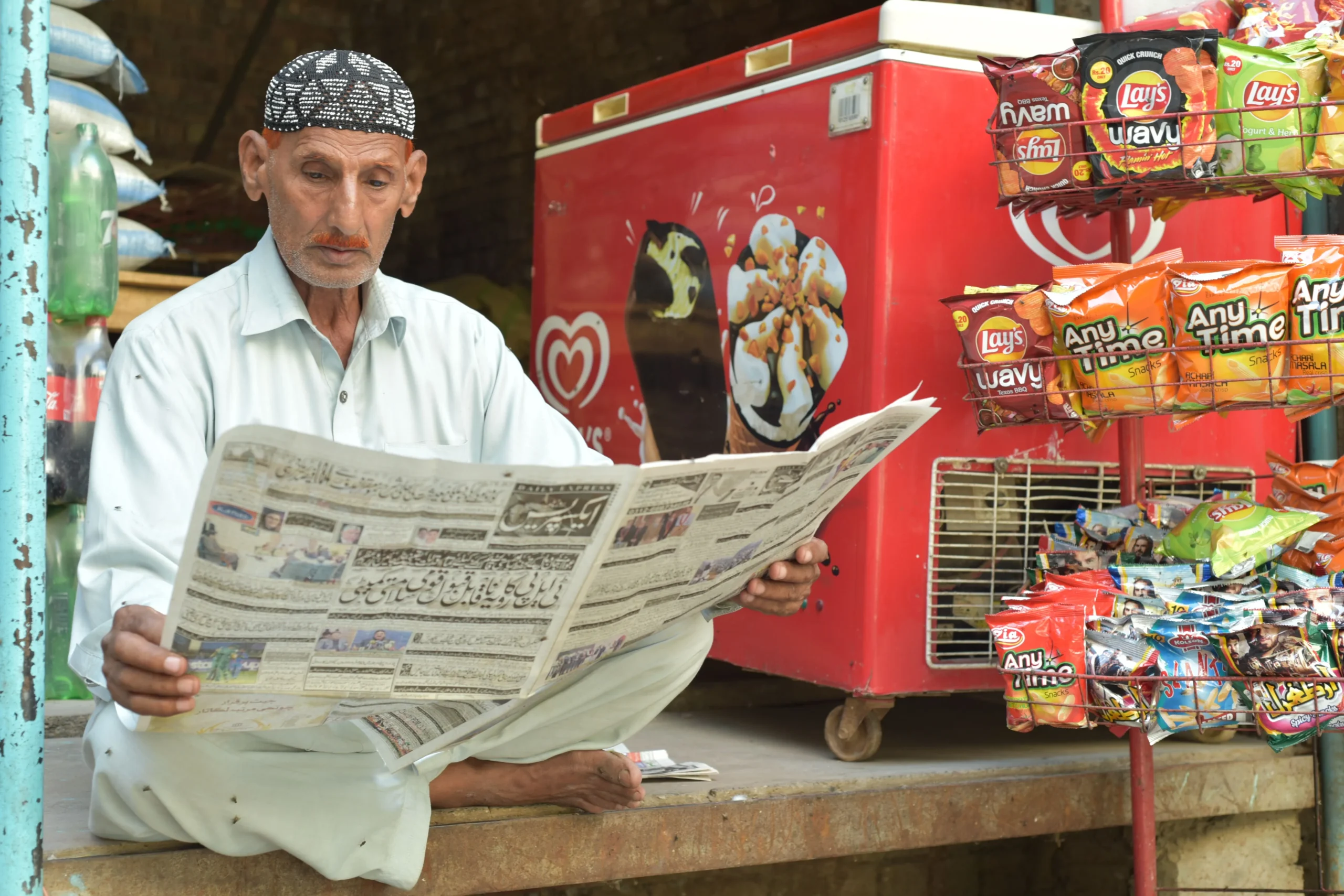 An old man is reading the newspaper.
