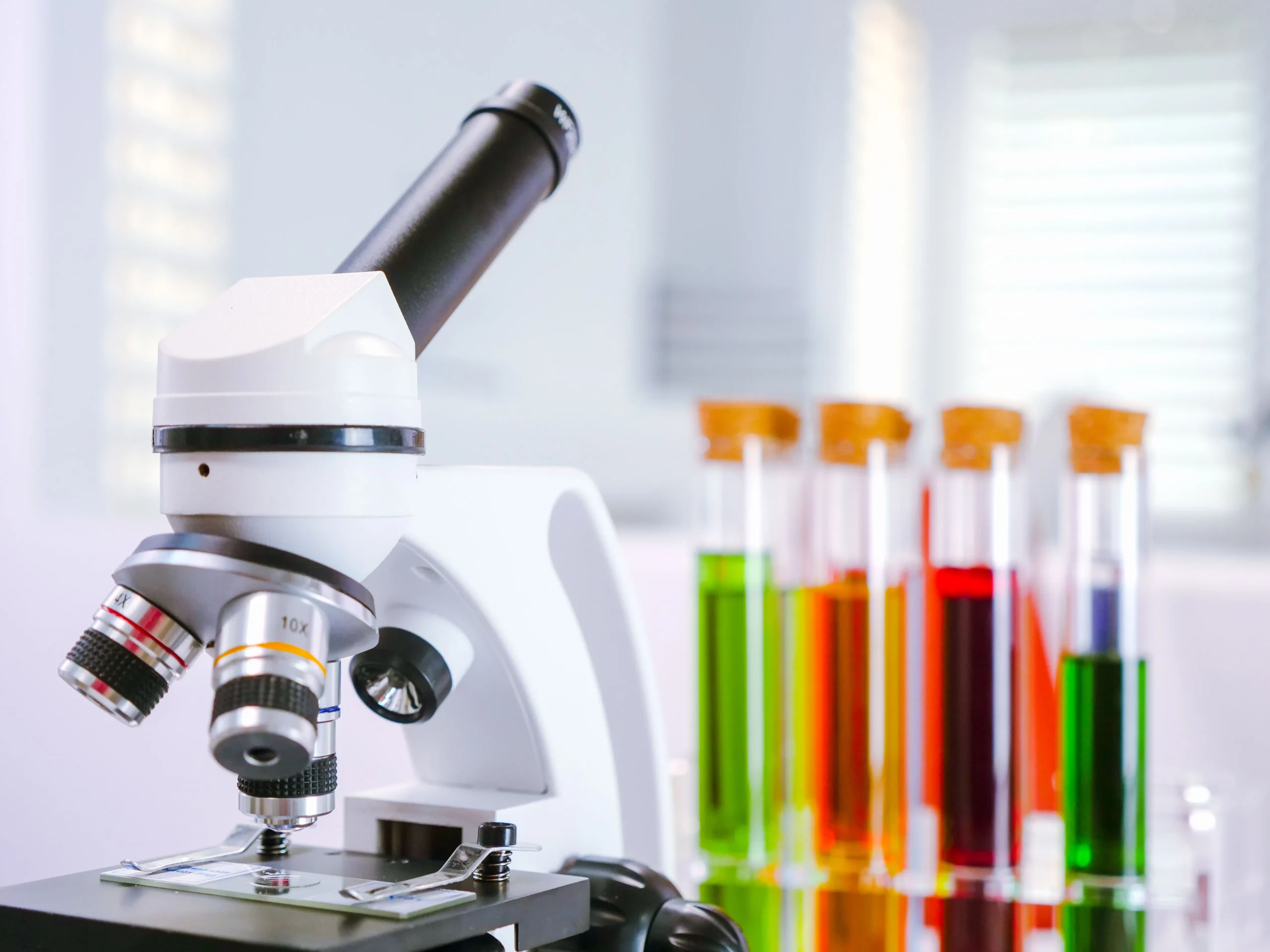 A microscope and test tubes are placed on the table.
